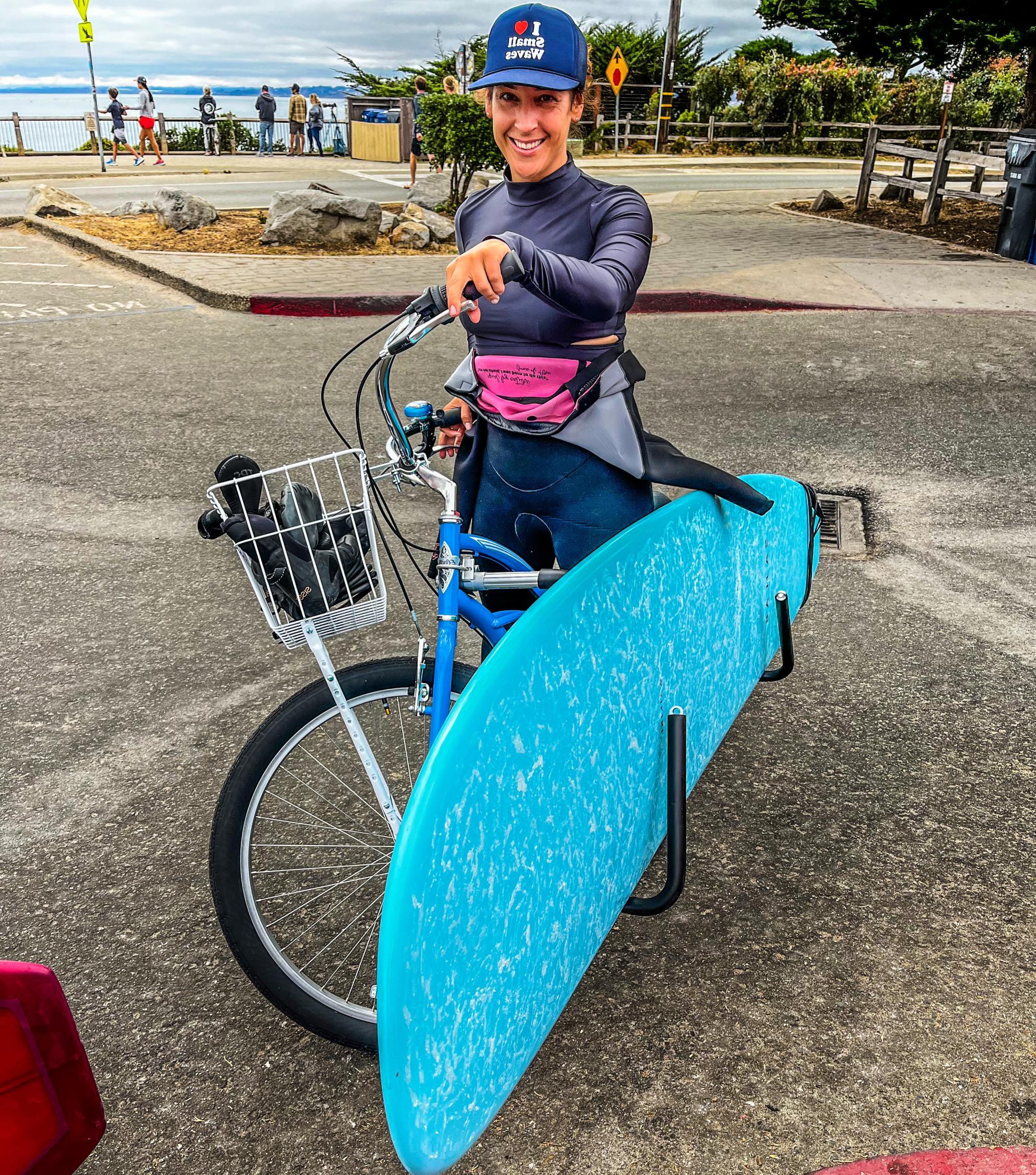 Suzanne next to bike with surfboard