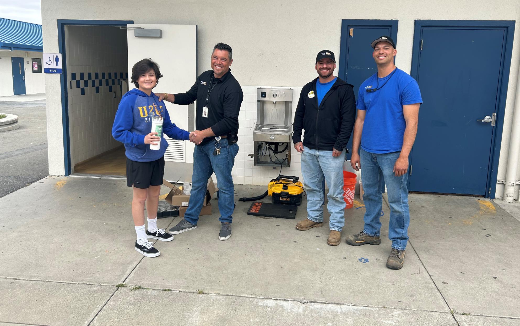 Richard Tapia with son and crew by fountain install at Ida Price Middle School